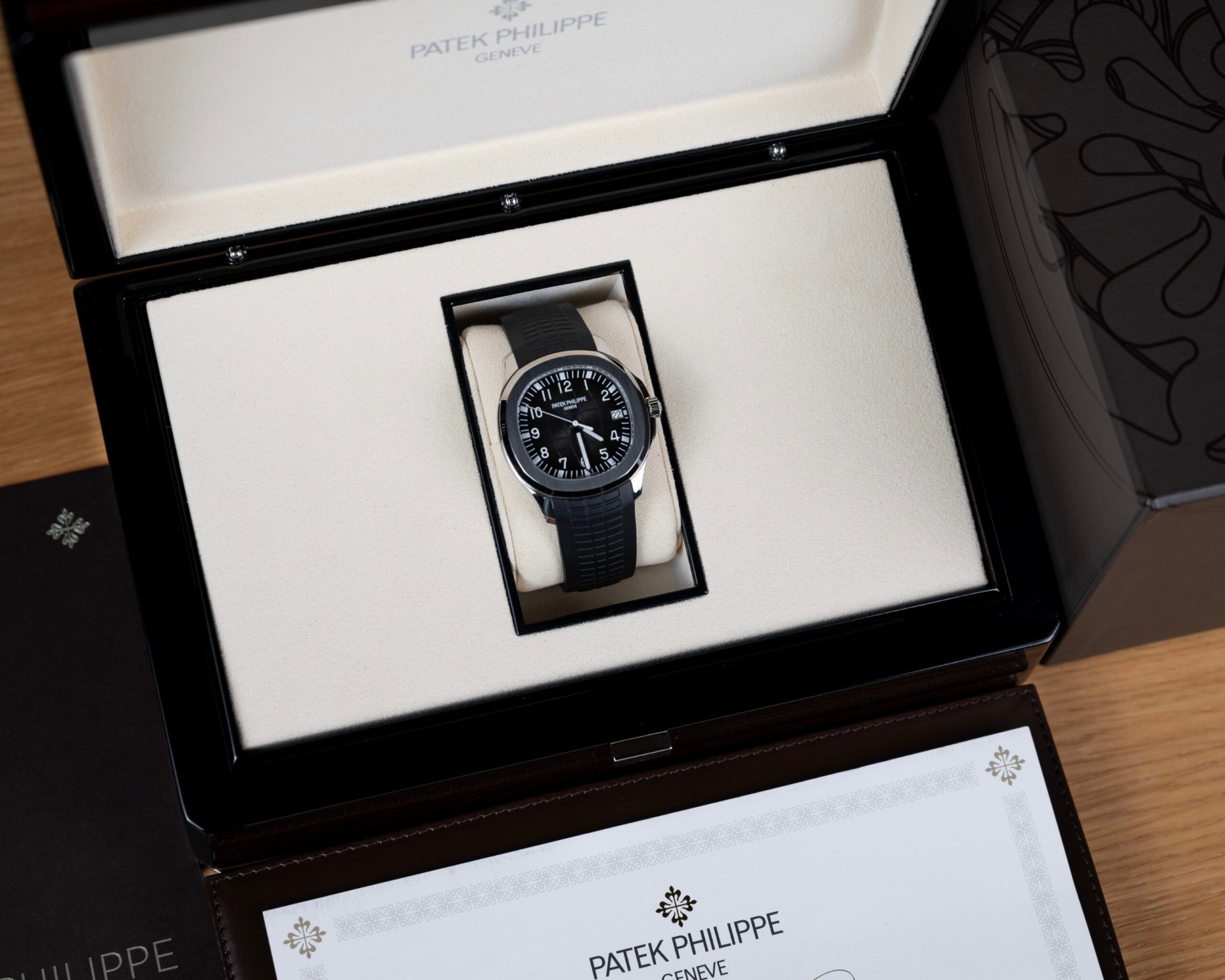 Steel sports watch with a black dial in its presentation box with certificate