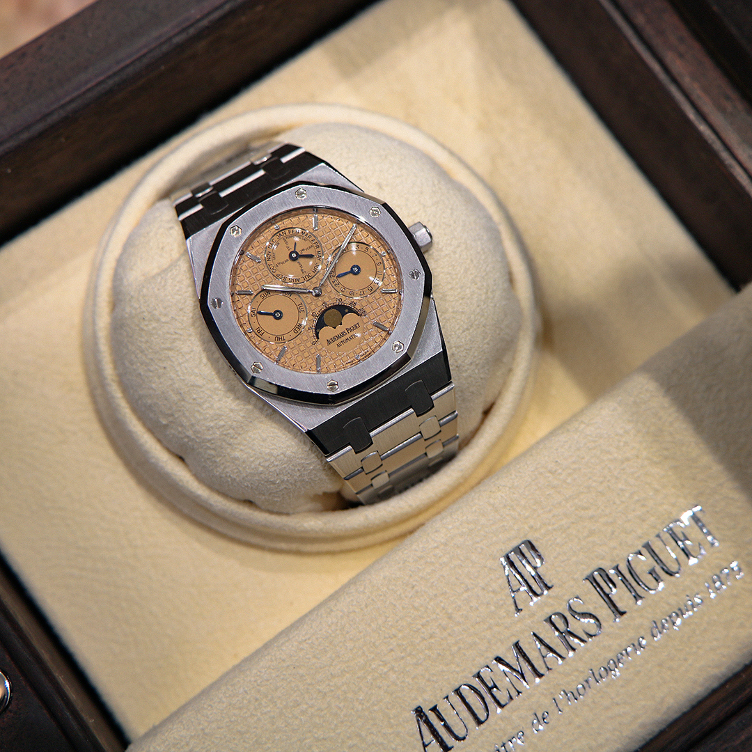 Steel sports watch with a salmon perpetual calendar dial in its presentation box